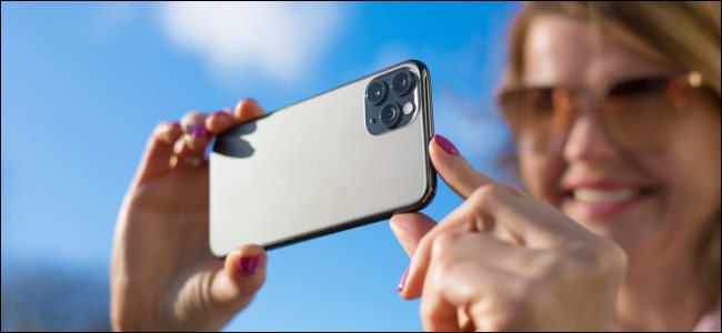Uma mulher tirando uma foto com um iPhone.