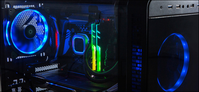 Um PC para jogos em uma sala escura com iluminação LED vermelha, verde, azul e amarela.