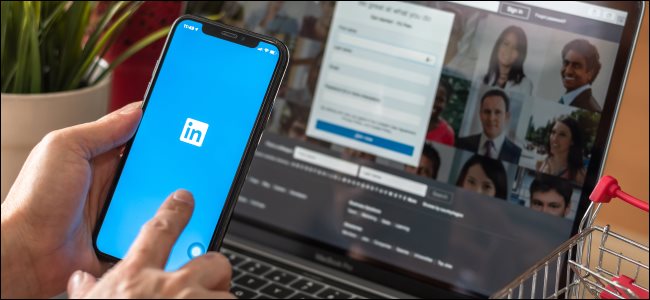 O aplicativo do LinkedIn em um smartphone e o site do LinkedIn em um MacBook.