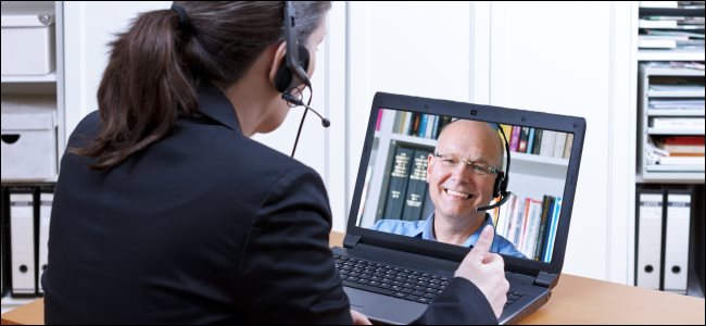 Uma mulher fazendo videoconferência com um homem em um laptop.