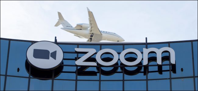 Um avião sobrevoando um prédio com o logotipo da Zoom.