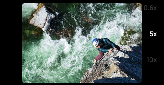 Foto de um homem em uma corda escalando as rochas ao lado de um rio intenso. 