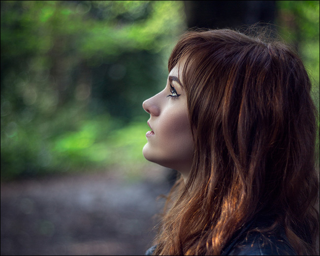 Retrato de uma mulher de perfil, olhando para cima.