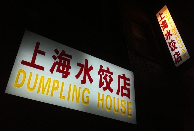 Uma foto noturna da placa iluminada do restaurante Dumpling House tirada com um iPhone 4.