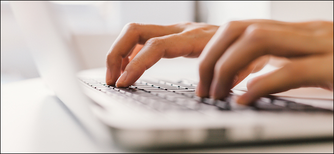 Pessoa digitando em um teclado de laptop