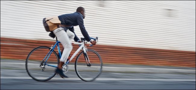 Um homem andando de bicicleta em uma rua da cidade.
