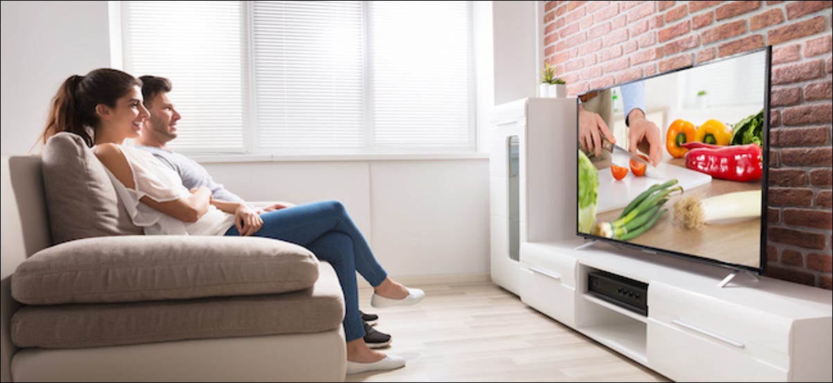 Um casal assiste a um programa de comida na TV
