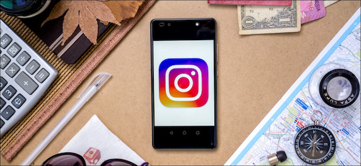 Logotipo do Instagram em um smartphone cercado por equipamentos de viagem