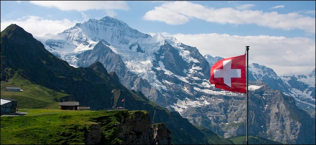 Bandeira suíça hasteada na frente de uma montanha