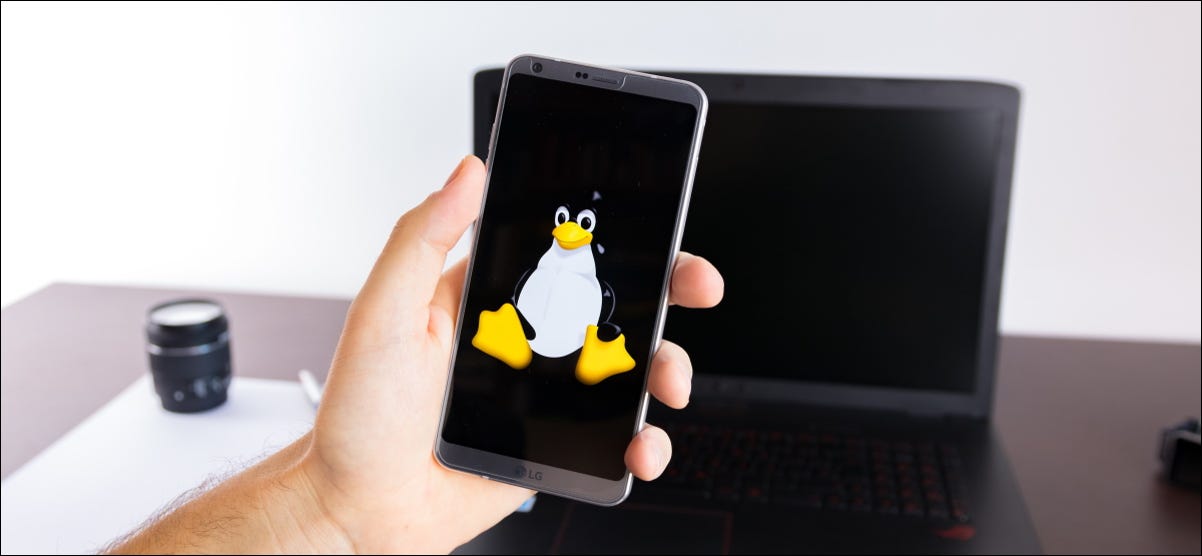 Um smartphone com o logotipo do Linux Tux na frente de um laptop.