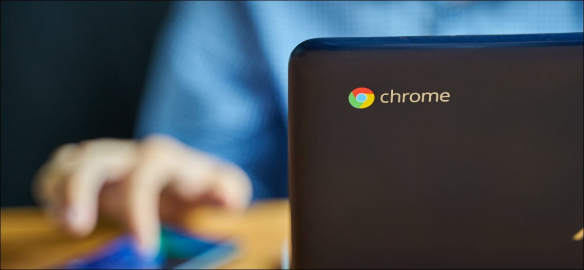 Um homem usando um Chromebook e um smartphone.