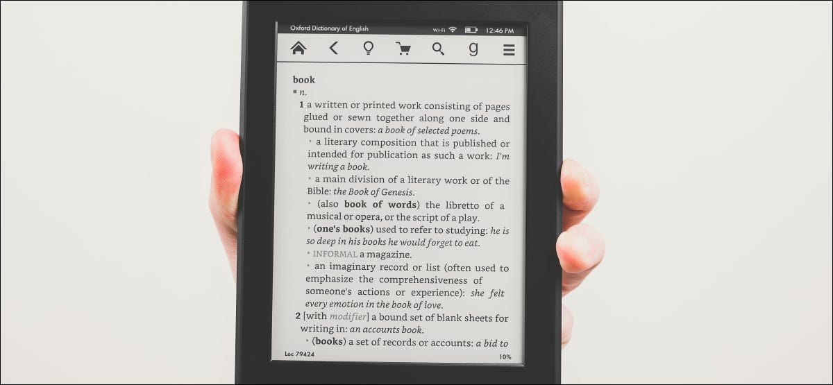 Uma mão segurando um leitor de e-book Kindle Paperwhite.