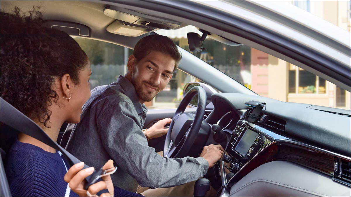 Duas pessoas em um veículo com um Echo Auto.