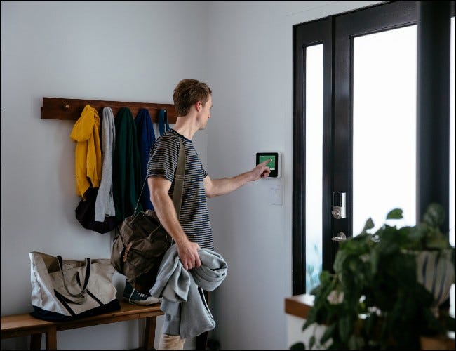 Homem usando painel touch-screen na porta da frente