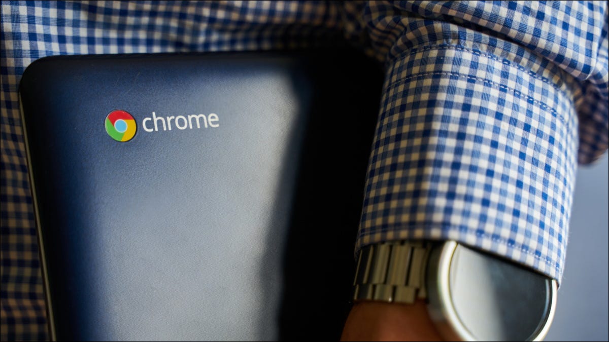 Uma pessoa segurando um Chromebook Asus debaixo do braço.