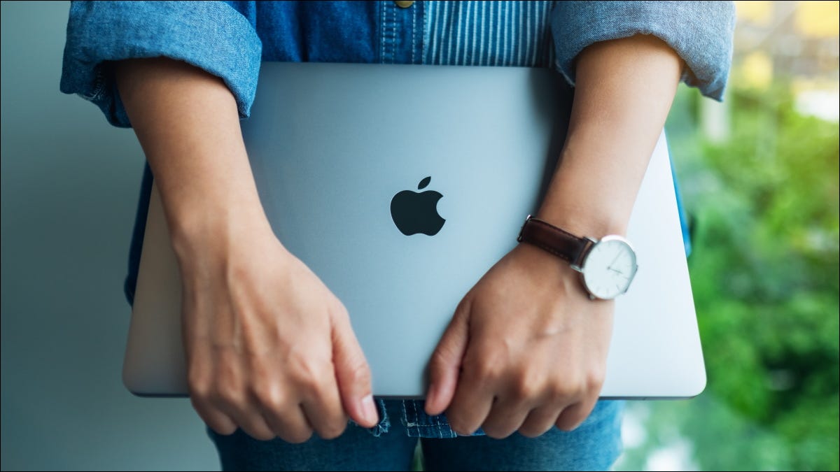 Uma mulher segurando um Apple MacBook Pro.