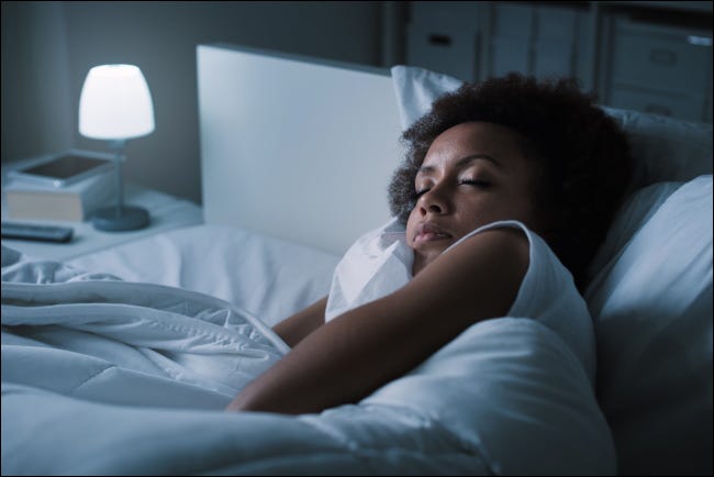 Uma mulher dormindo em sua cama à noite.