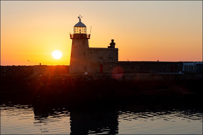 nascer do sol sobre um farol