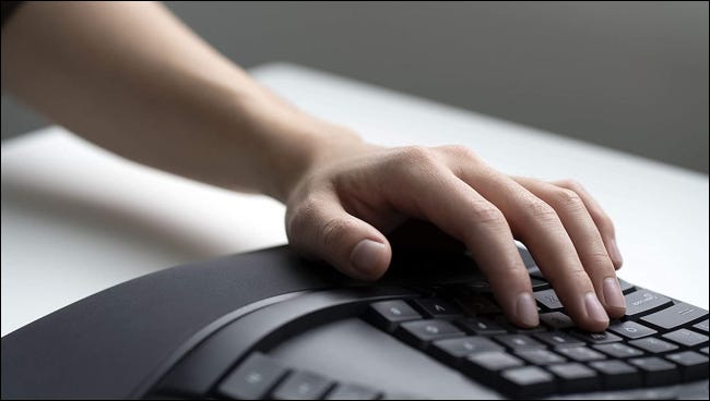 pessoa usando o teclado ergonômico da Microsoft