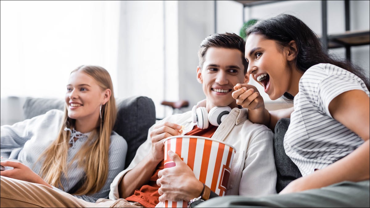 Família sentada em um casal assistindo Netflix