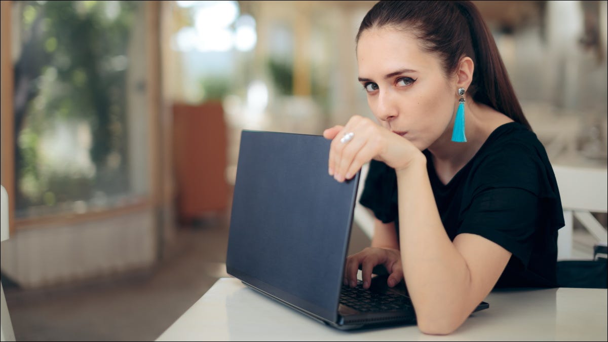 Uma mulher preocupada protegendo um laptop.