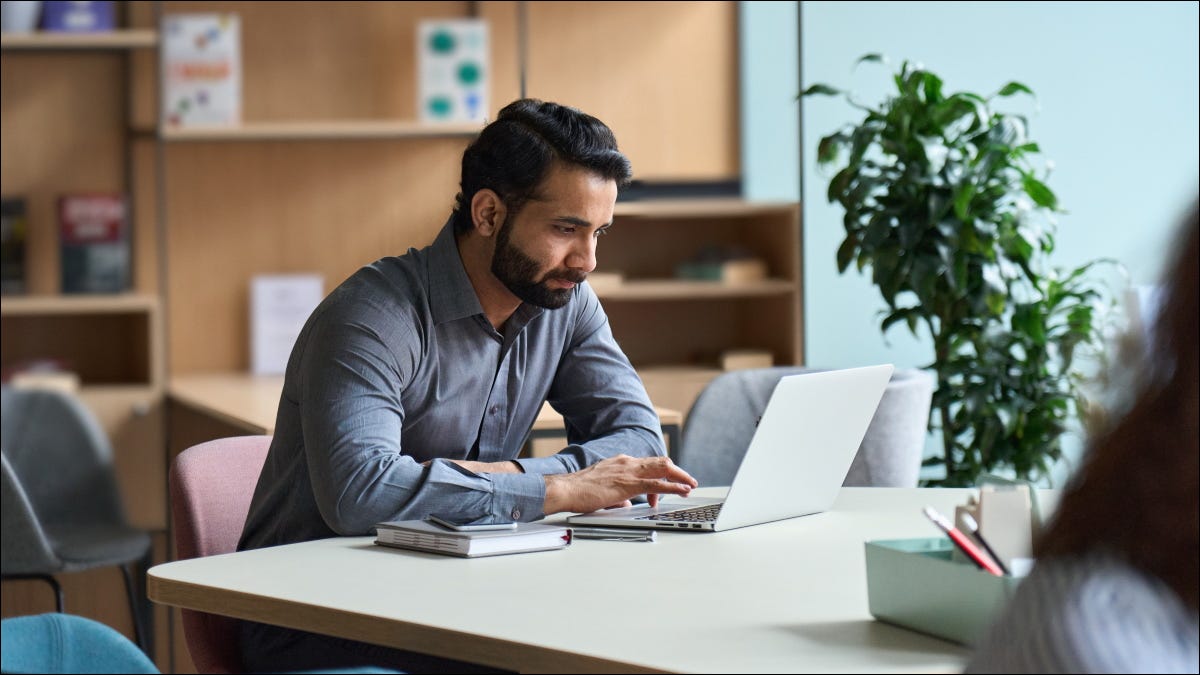 Um homem que trabalha em um laptop em um escritório.