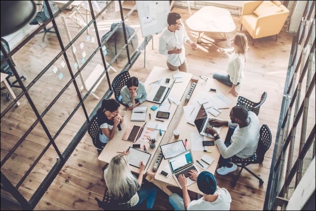 Pessoas que trabalham em uma mesa em um escritório.