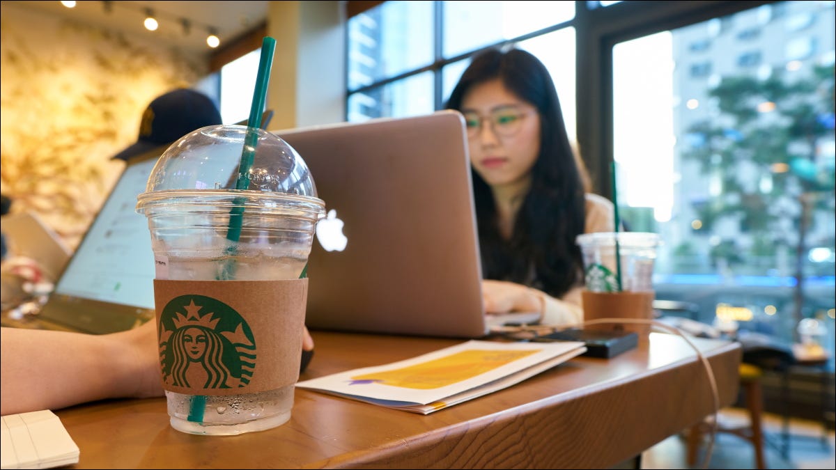 Pessoas trabalhando em laptops em um restaurante Starbucks.