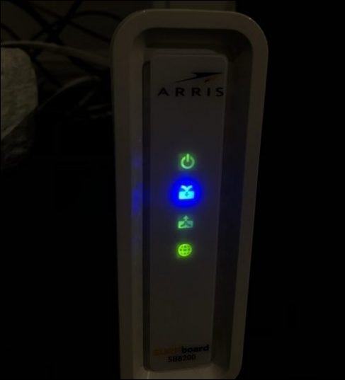 Um modem de rede com quatro luzes acesas