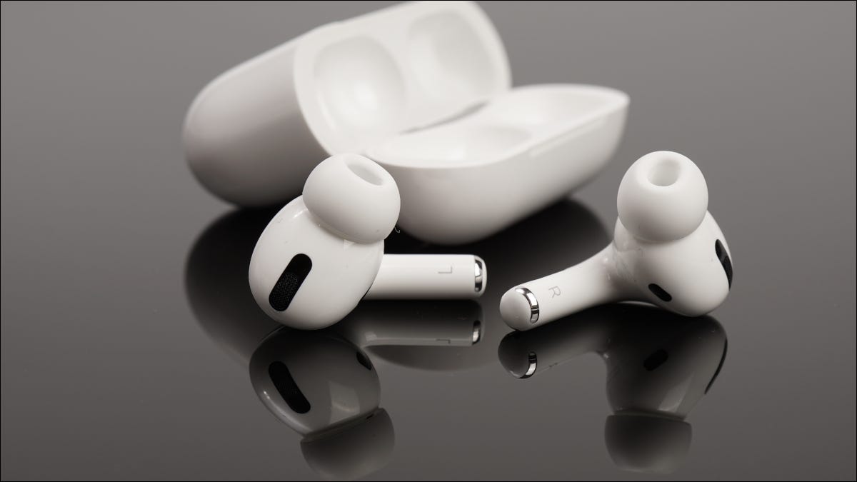 Airpods e capa da Apple em uma superfície reflexiva escura