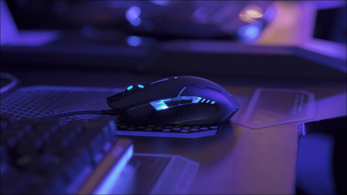 Mouse para jogos iluminado na mesa do computador com luz azul
