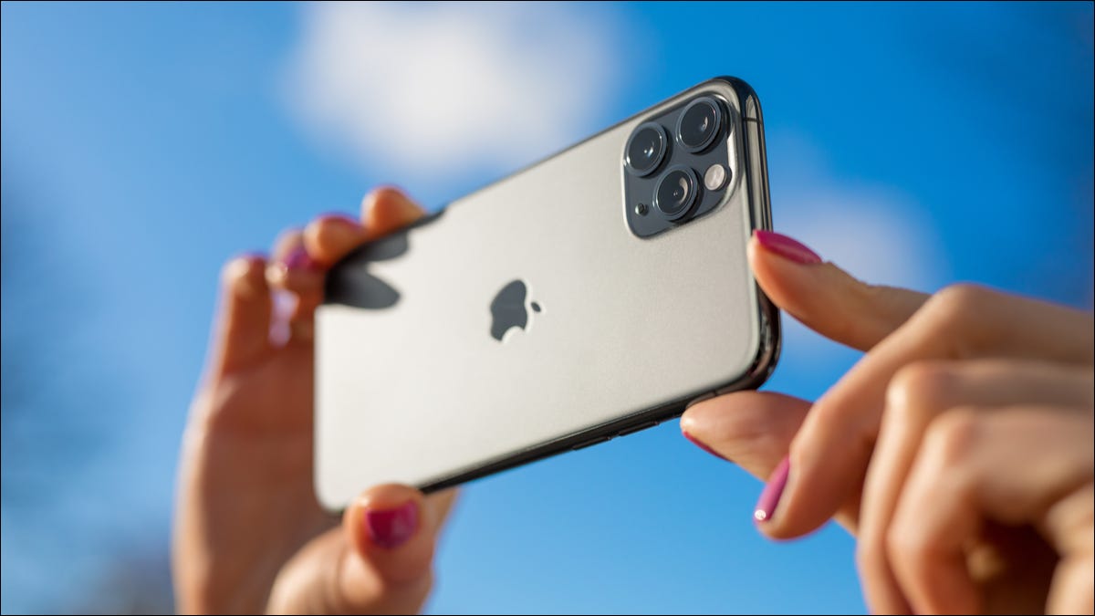 Uma pessoa tirando uma foto do lado de fora com um iPhone.