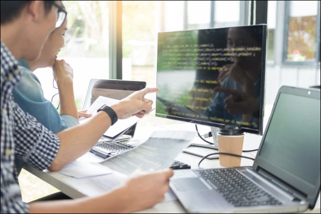 Duas pessoas codificando juntas em um computador