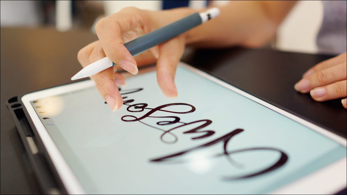 Mulher criando arte gráfica em um iPad com um lápis da Apple