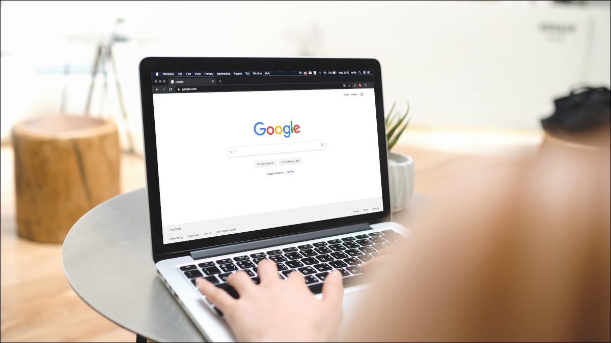 Mulher digitando em um laptop com a Pesquisa do Google aberta no navegador