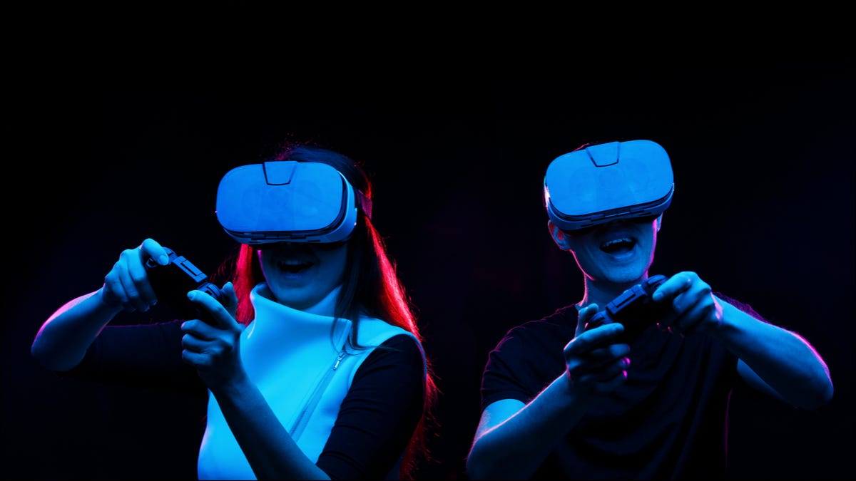 Um casal jogando em fones de ouvido de realidade virtual.