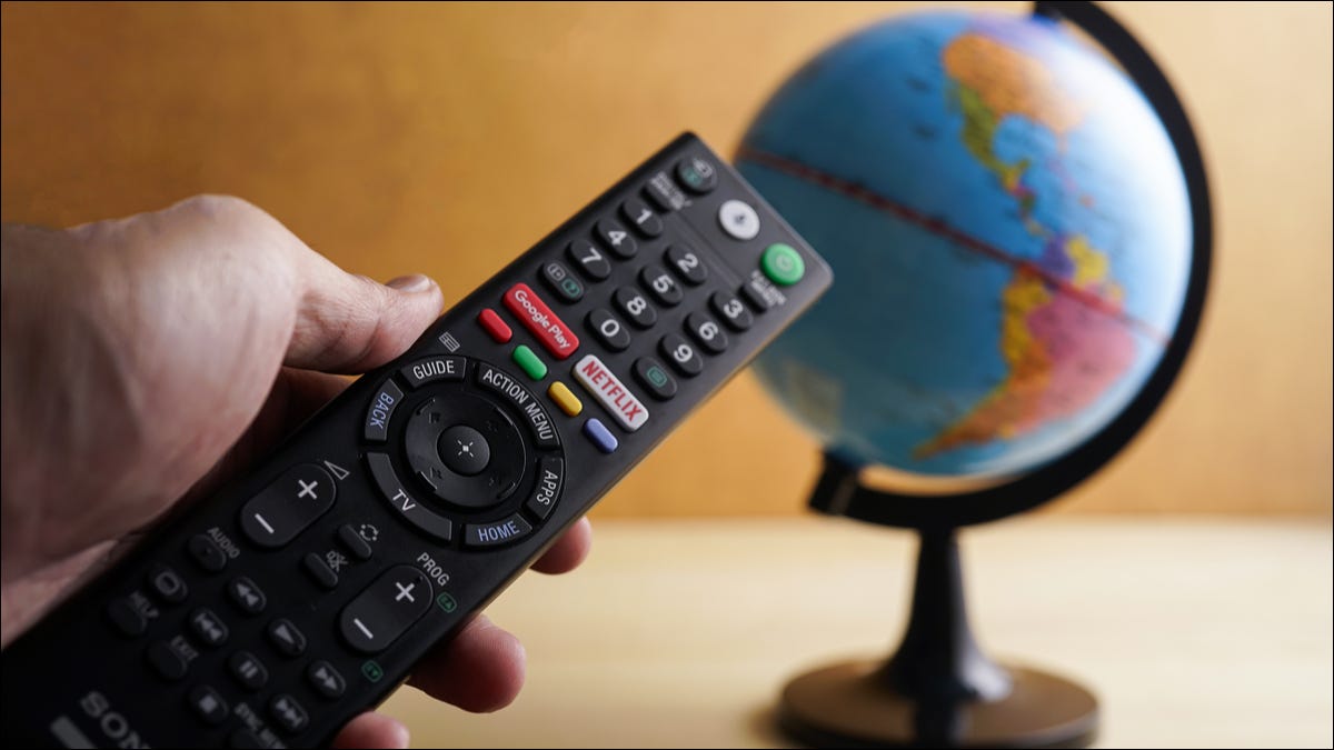 Um controle remoto com um botão Netflix apontado para um globo.