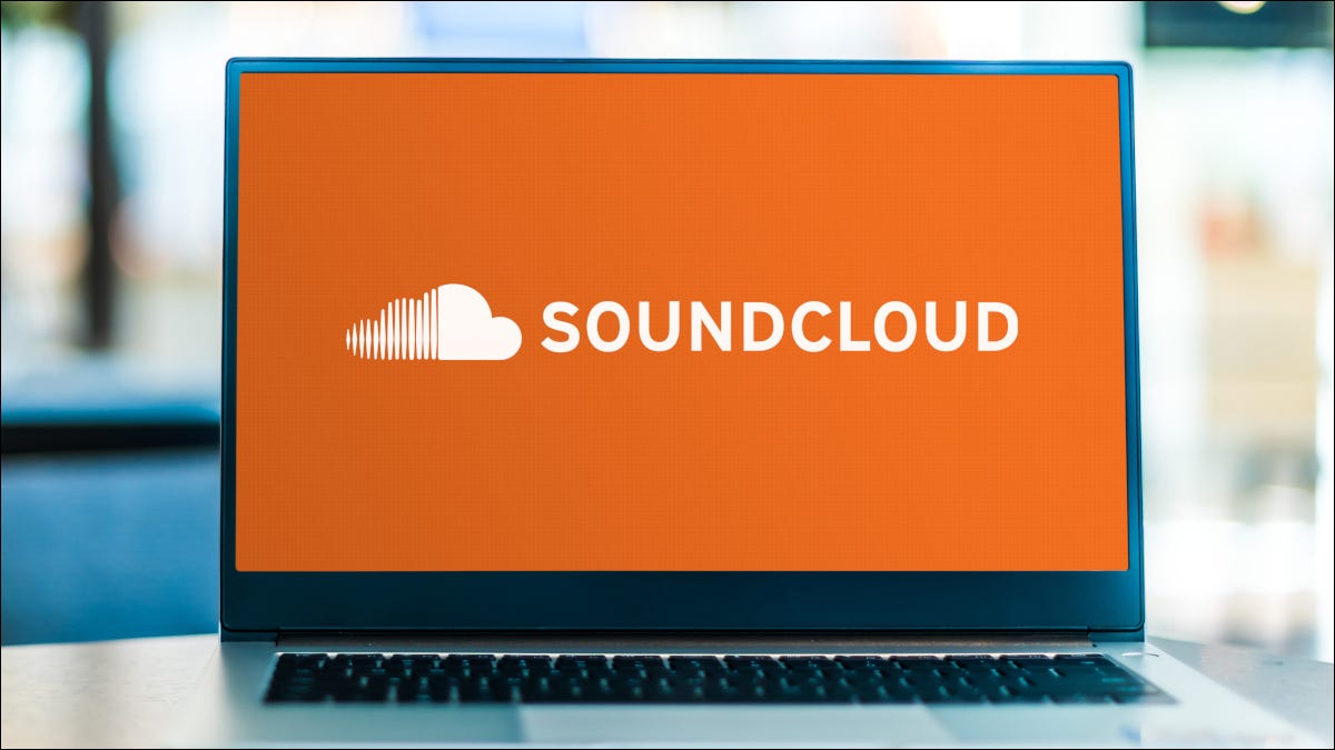 Abra o laptop exibindo o logotipo do Soundcloud em um fundo laranja