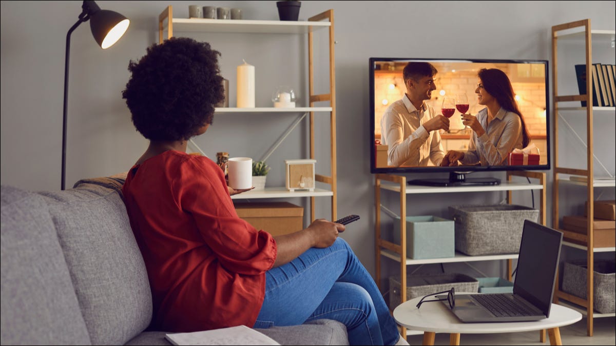 mulher assistindo tv na sala de estar