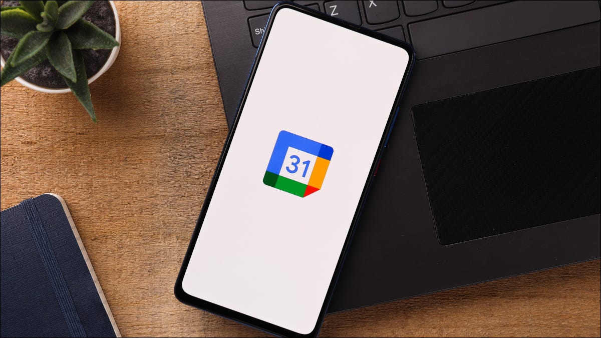 Smartphone em cima de um laptop com o logotipo do Google Agenda exibido