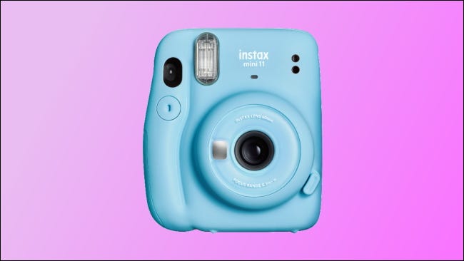 mini câmera instantânea instax em fundo rosa