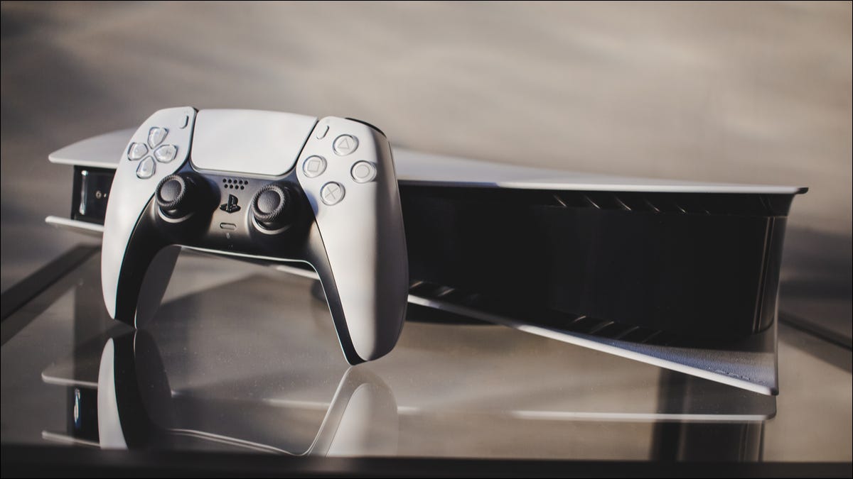 Playstation 5 and controller on glass table