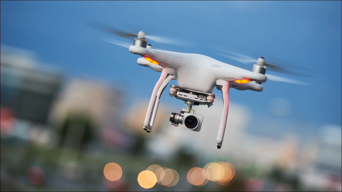 Um drone quadricóptero voador com uma câmera acoplada.