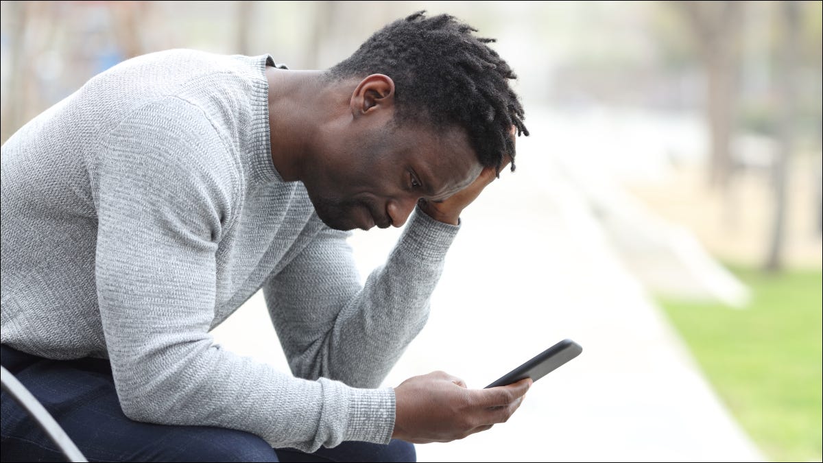 Homem cansado esperando e olhando para o telefone