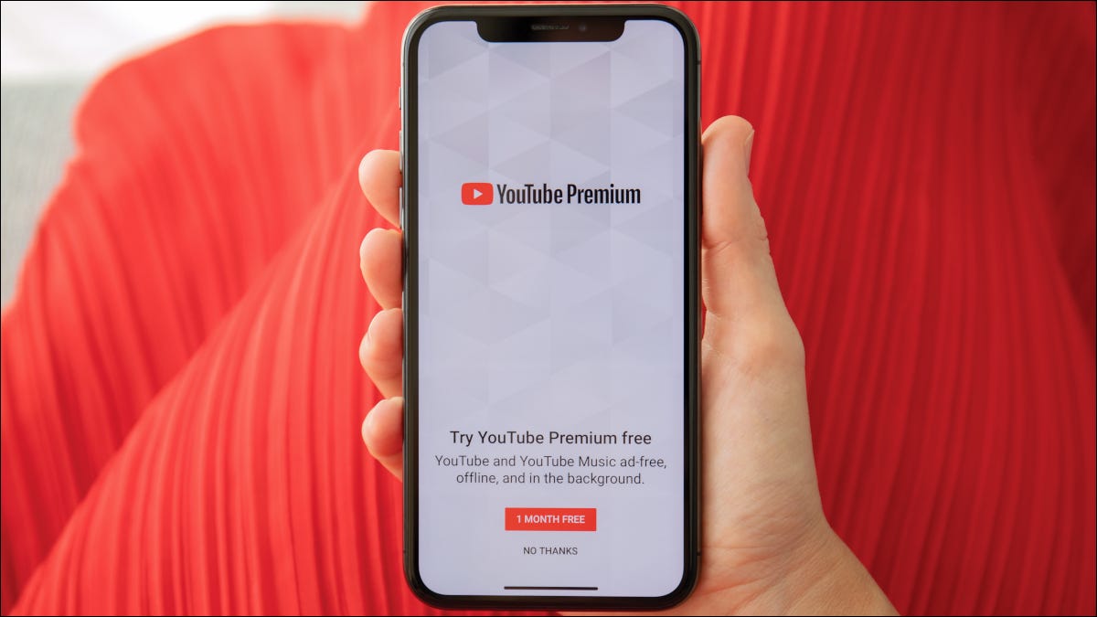 Mão segurando smartphone exibindo página de inscrição no YouTube Premium