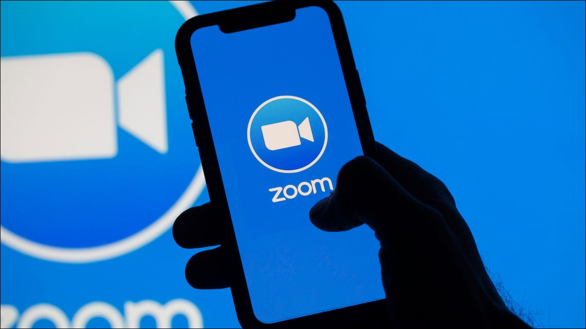 Logotipo da Zoom em um smartphone e monitor de computador