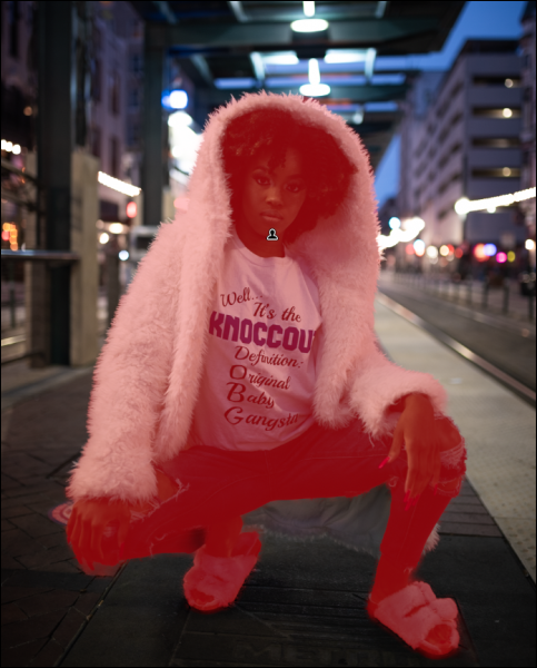 Retrato de uma mulher agachada no chão, a mulher é destacada em vermelho.