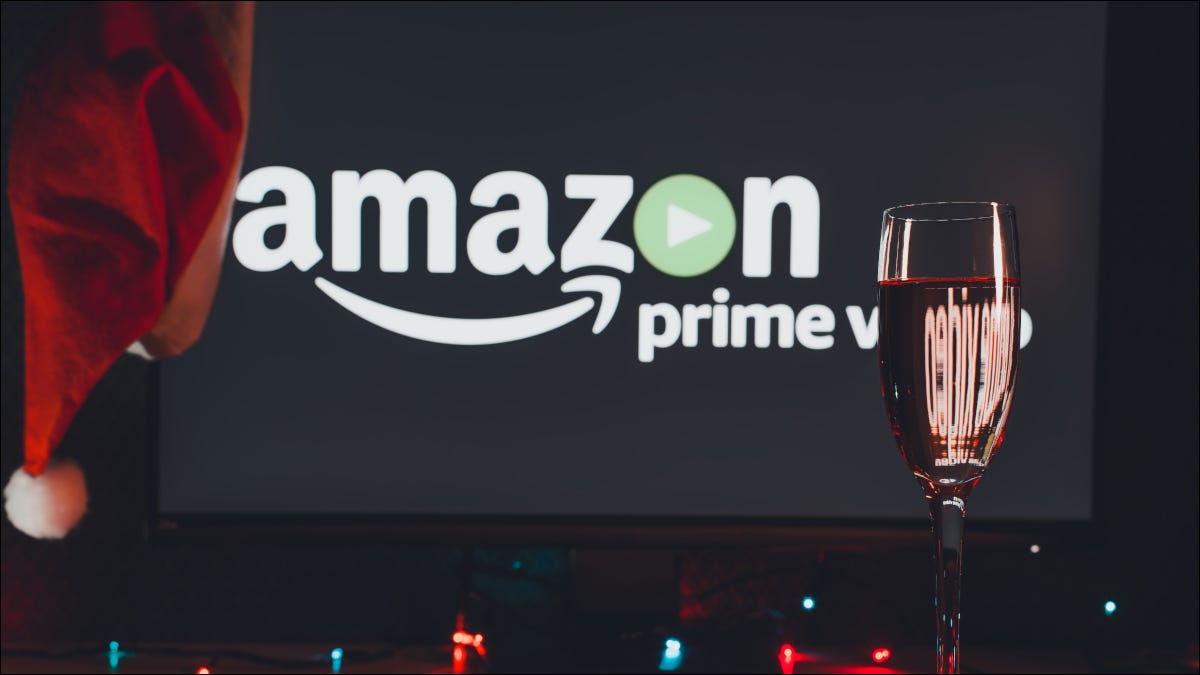 Logotipo do Amazon Prime Video em uma TV com um chapéu de Papai Noel atrás de uma taça de vinho