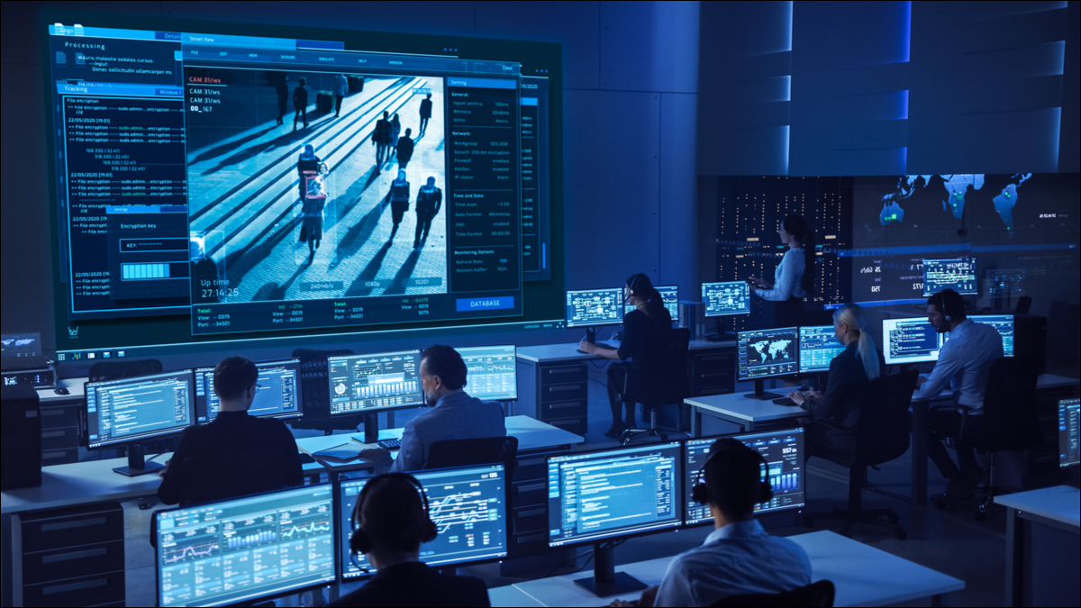 Uma equipe profissional de segurança cibernética operando em frente a uma tela grande.