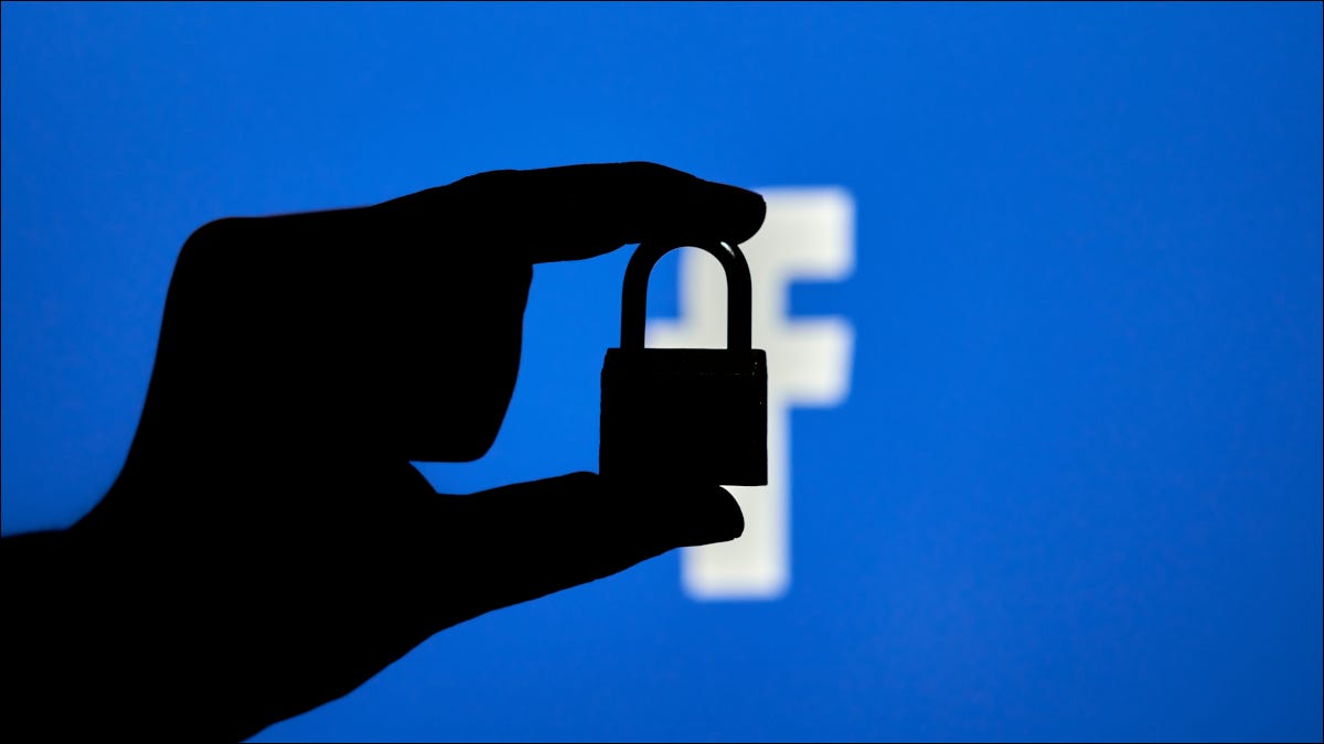 Silhueta de uma mão segurando um cadeado fechado sobre o logotipo do Facebook